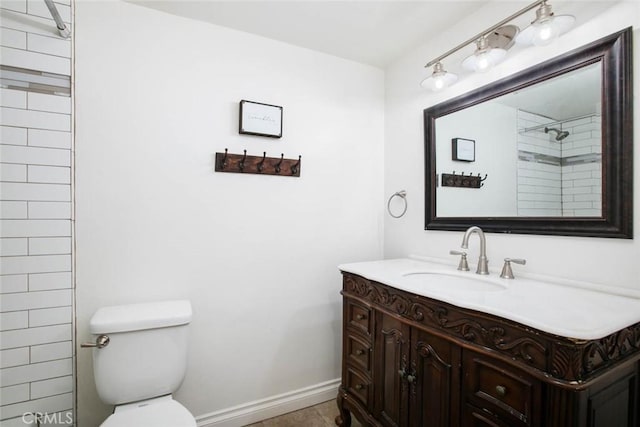 bathroom featuring vanity, toilet, and a tile shower