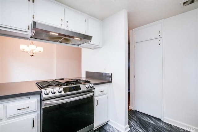 kitchen featuring stainless steel gas range oven, white cabinets, and a notable chandelier