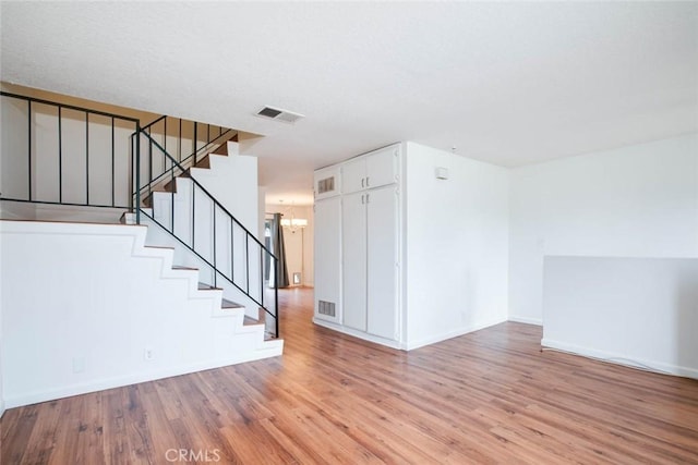 unfurnished room featuring light hardwood / wood-style floors and a chandelier