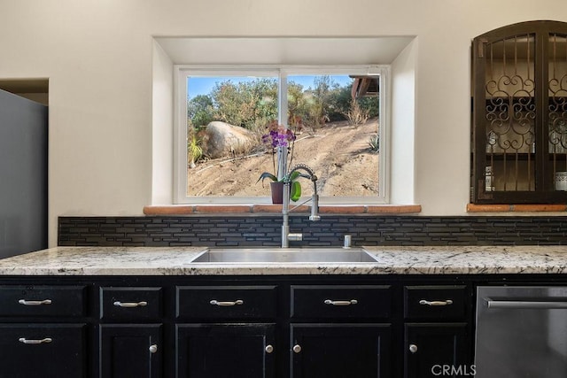 bar with decorative backsplash, sink, stainless steel dishwasher, and light stone countertops