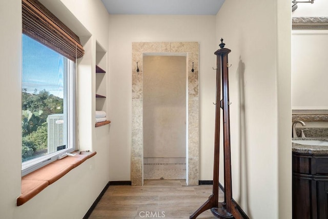 corridor featuring light wood-type flooring and sink