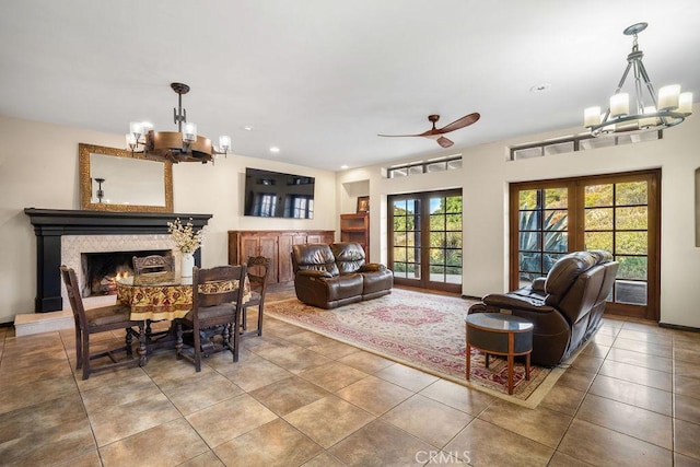 tiled living room featuring ceiling fan with notable chandelier, french doors, and a healthy amount of sunlight