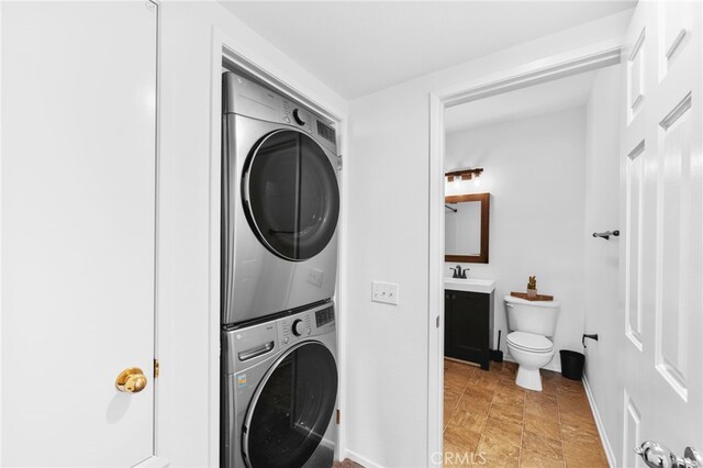 clothes washing area with sink and stacked washer and clothes dryer