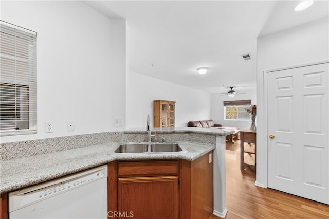 kitchen featuring white dishwasher, sink, light hardwood / wood-style flooring, ceiling fan, and kitchen peninsula