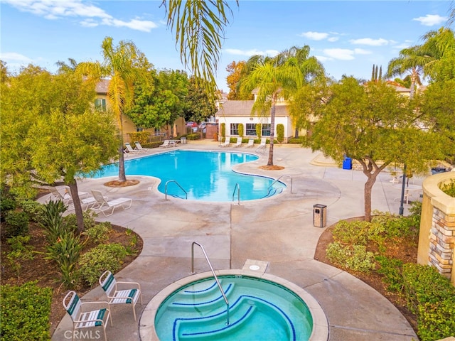 view of swimming pool with a patio area and a community hot tub