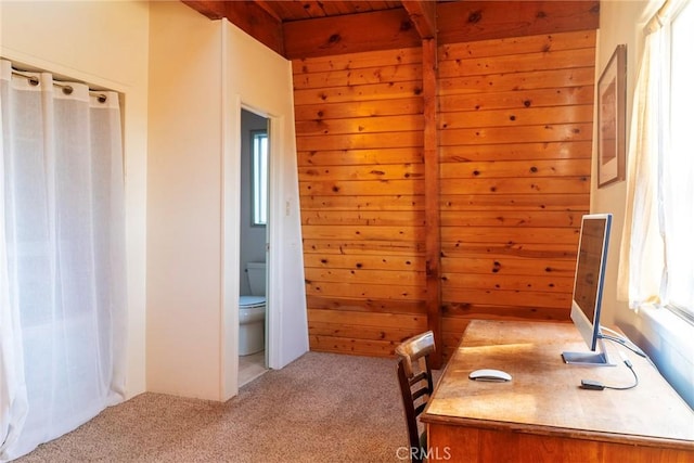 unfurnished office featuring light carpet, beamed ceiling, wooden walls, and wood ceiling