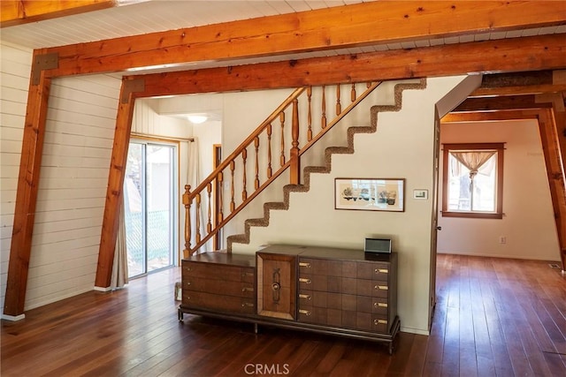 stairway with beamed ceiling, hardwood / wood-style floors, and wood ceiling