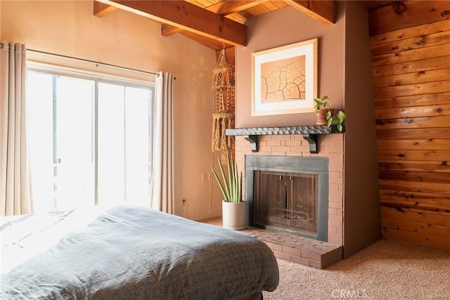 carpeted bedroom featuring beamed ceiling, a brick fireplace, and wood ceiling