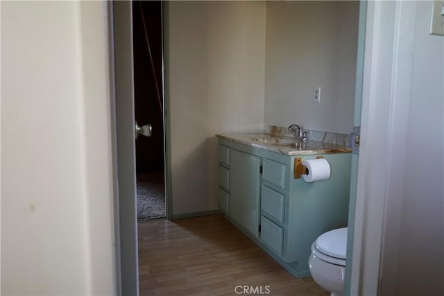 bathroom with toilet, vanity, and hardwood / wood-style flooring