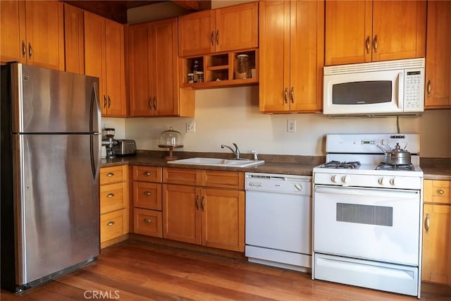 kitchen with white appliances, dark hardwood / wood-style floors, and sink