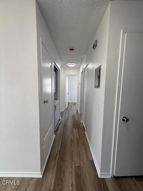 hallway featuring dark wood-type flooring and a textured ceiling