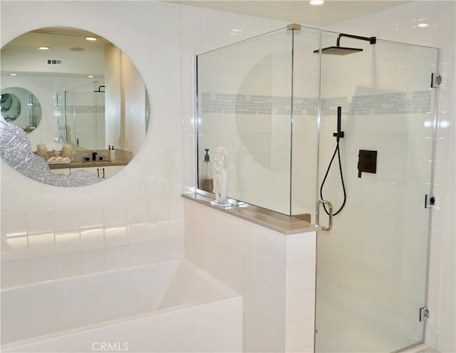 bathroom featuring shower with separate bathtub