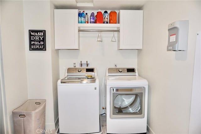 laundry room with washer and clothes dryer and cabinets