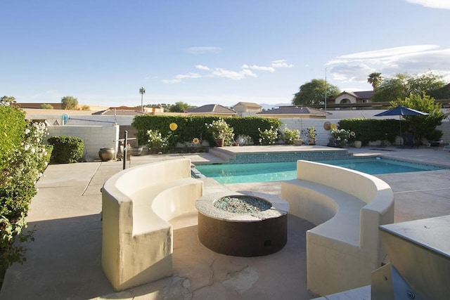 view of swimming pool featuring a patio area and an outdoor fire pit