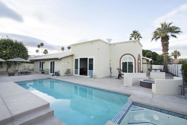 view of swimming pool featuring an in ground hot tub, a patio area, and a fire pit