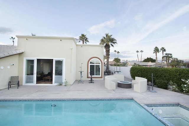 rear view of property featuring an outdoor fire pit, a fenced in pool, and a patio