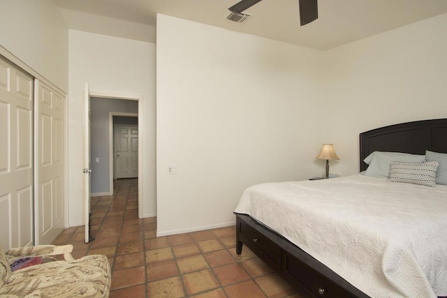 tiled bedroom with ceiling fan and a closet