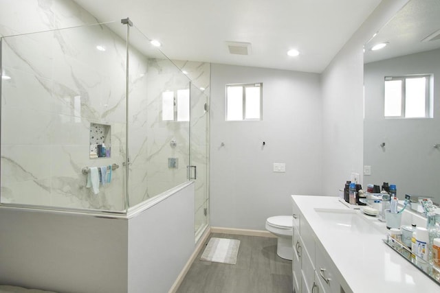 bathroom with hardwood / wood-style floors, lofted ceiling, vanity, an enclosed shower, and toilet