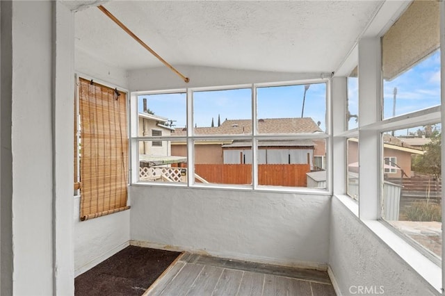 unfurnished sunroom featuring a wealth of natural light and vaulted ceiling