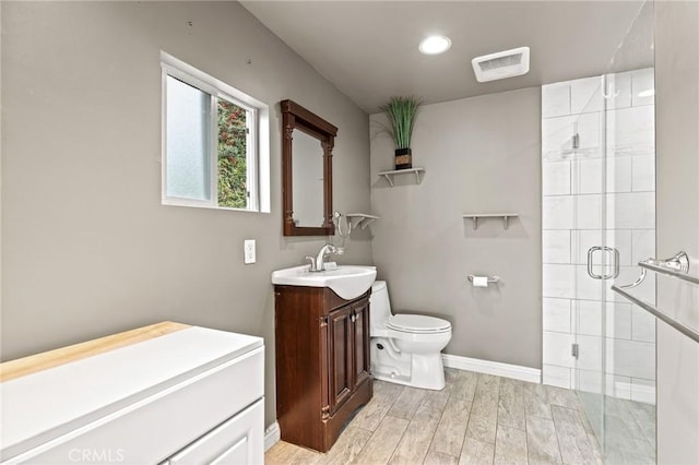 bathroom featuring hardwood / wood-style floors, vanity, an enclosed shower, and toilet