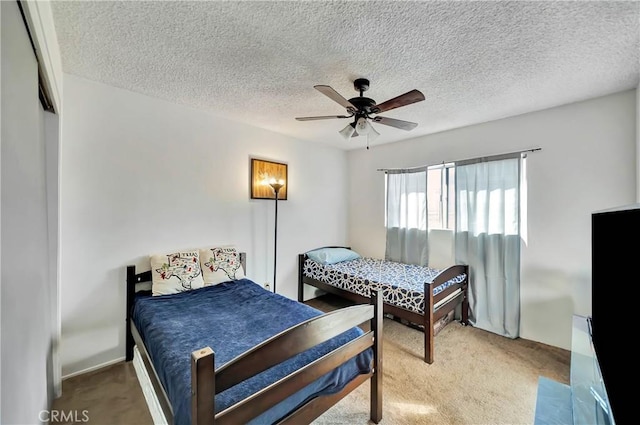 bedroom featuring carpet flooring, ceiling fan, and a textured ceiling