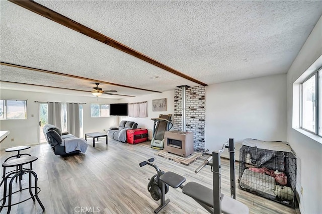 exercise area with ceiling fan, plenty of natural light, light hardwood / wood-style floors, and a textured ceiling