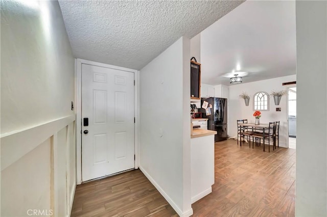 interior space with a textured ceiling and light wood-type flooring