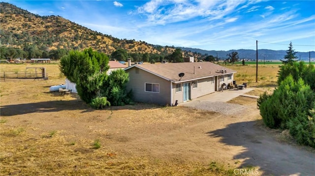 exterior space with a patio area, a mountain view, and a rural view