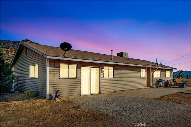 back house at dusk with a patio area