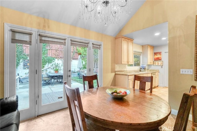 dining area with french doors, a chandelier, vaulted ceiling, and sink