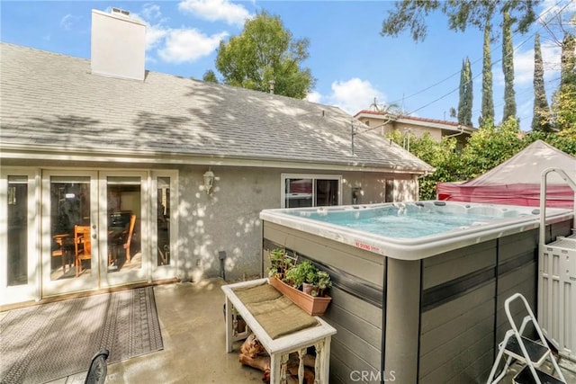 rear view of property with a hot tub