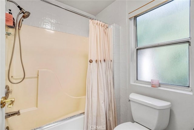 bathroom featuring a healthy amount of sunlight, shower / bath combo, and toilet