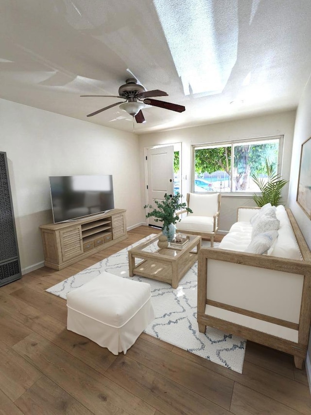 living room with ceiling fan, a textured ceiling, and hardwood / wood-style flooring