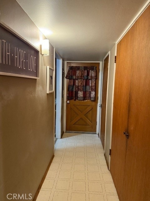 hall with tile patterned floors and a textured ceiling