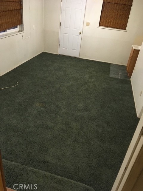 spare room featuring dark colored carpet