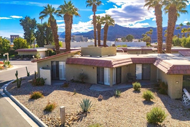 view of front of home with a patio and a mountain view