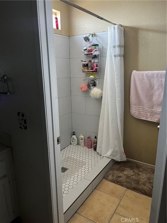 bathroom with tile patterned flooring and walk in shower