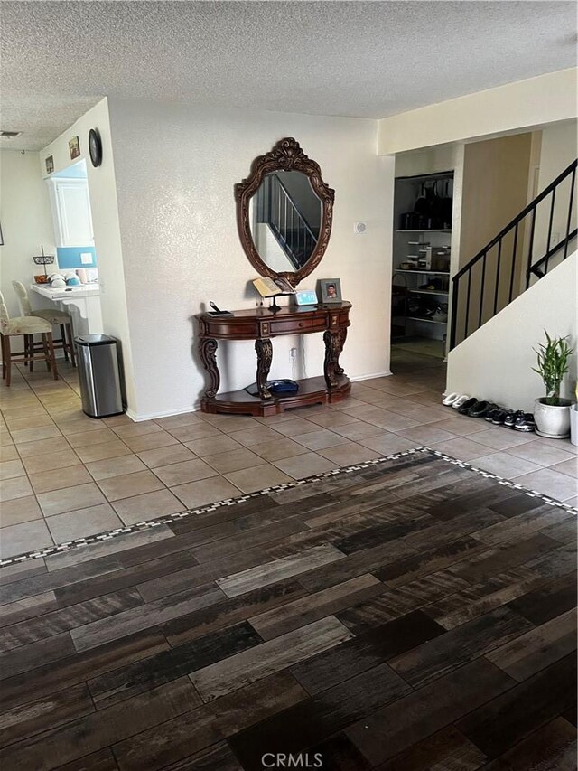 corridor with hardwood / wood-style floors and a textured ceiling