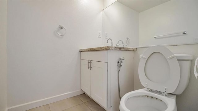 bathroom with toilet, tile patterned flooring, and vanity