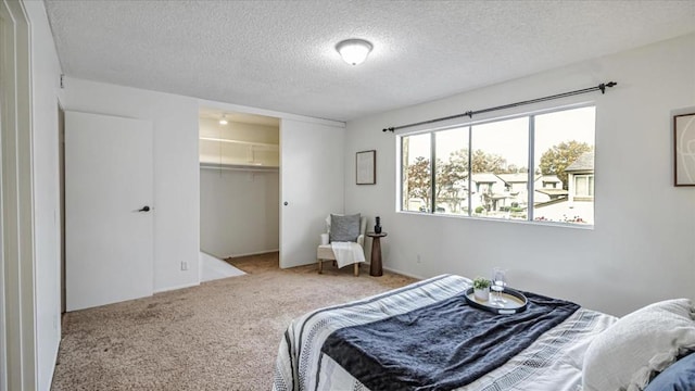 bedroom with a textured ceiling, carpet flooring, and a closet