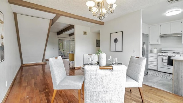 dining room featuring a textured ceiling, an inviting chandelier, hardwood / wood-style flooring, and beam ceiling