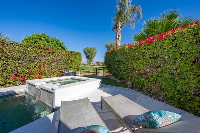 view of pool featuring an in ground hot tub and pool water feature