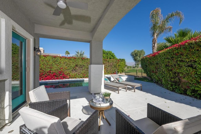 view of patio / terrace with outdoor lounge area, a fenced in pool, and ceiling fan