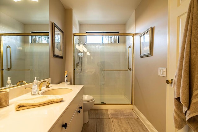 bathroom with vanity, toilet, and a shower with shower door