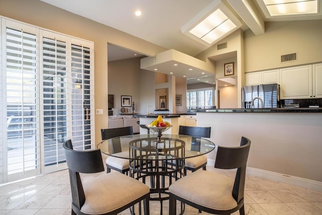 dining space featuring beamed ceiling and high vaulted ceiling