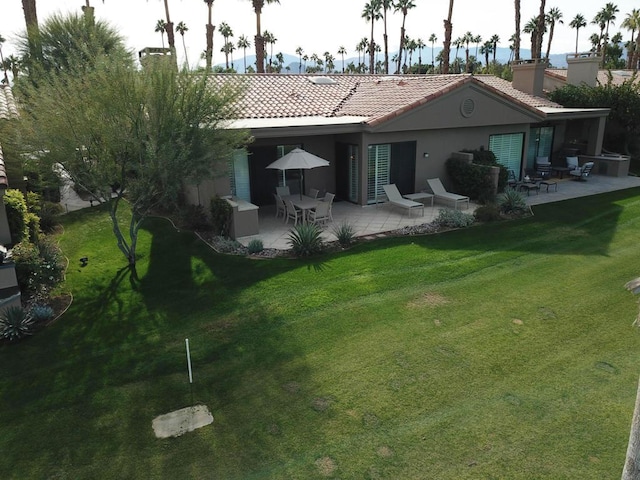 rear view of house with a lawn and a patio area