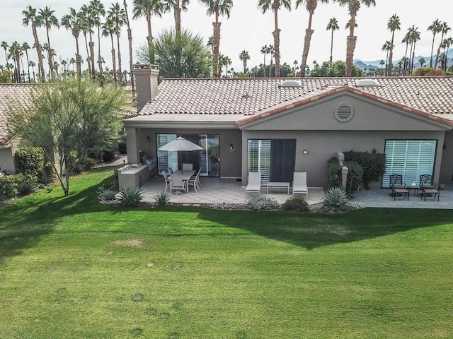 rear view of property featuring a yard and a patio