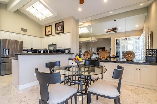 dining room with high vaulted ceiling and ceiling fan