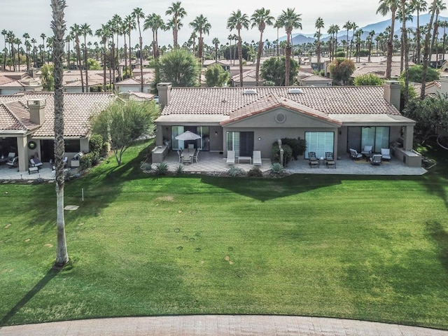 rear view of house with a lawn and a patio