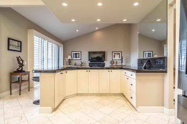 kitchen featuring lofted ceiling and kitchen peninsula